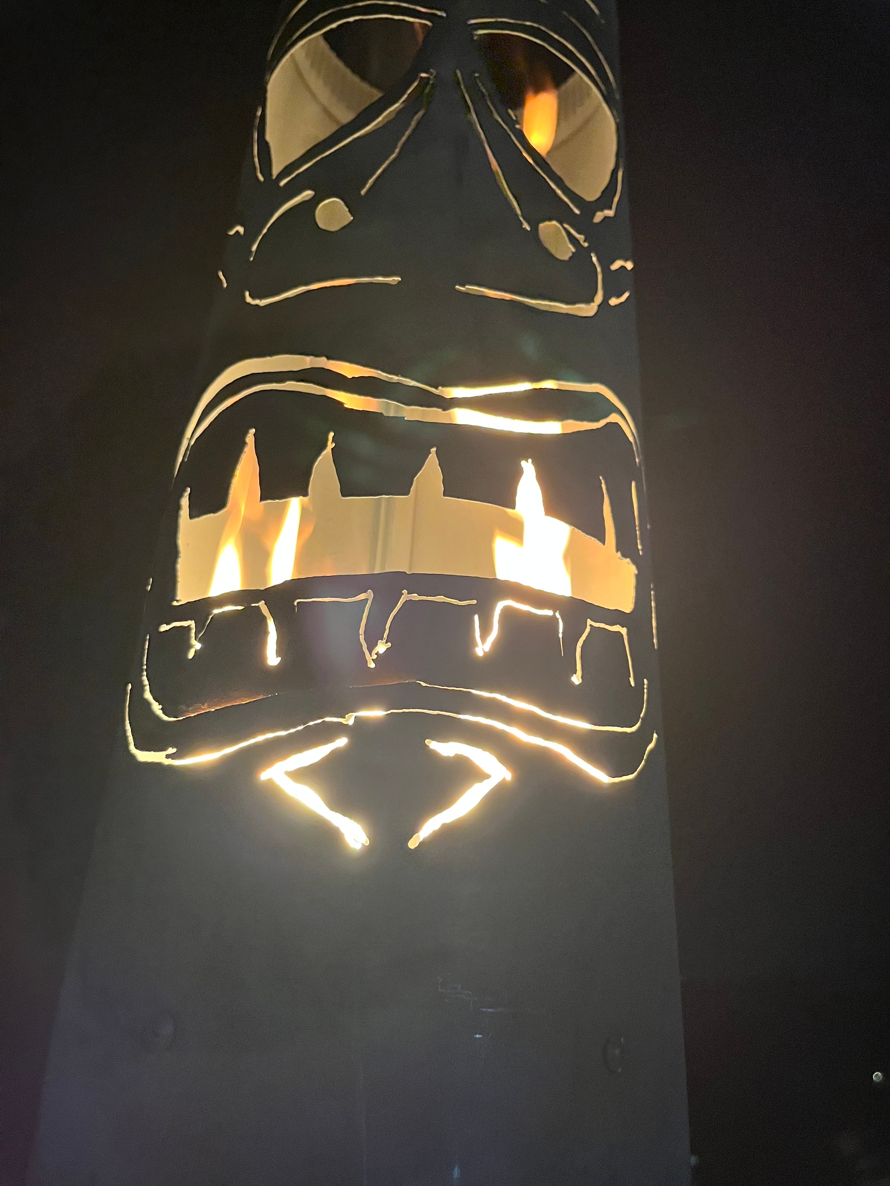 Fire breathing tiki props and luau decorations at an outdoor event