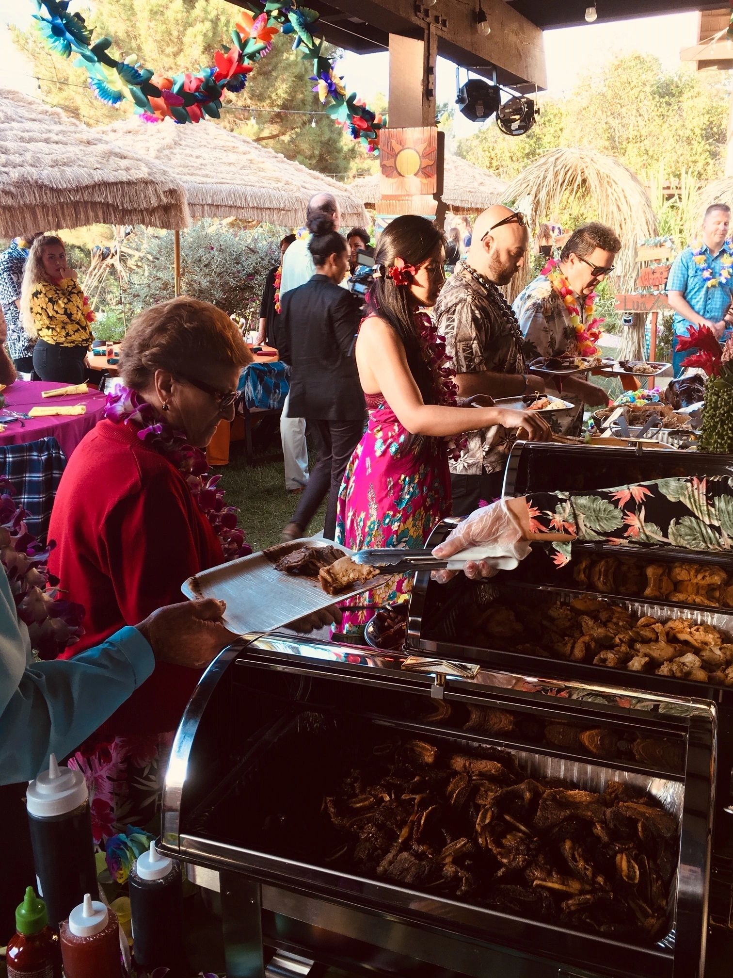 Hawaiian catering spread — kalua pork, BBQ chicken, and tropical sides
